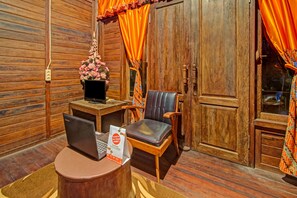 A wooden interior with a desk, laptop, chair, and a door with curtains. - OYO 90031 Villa Papada (Batu)