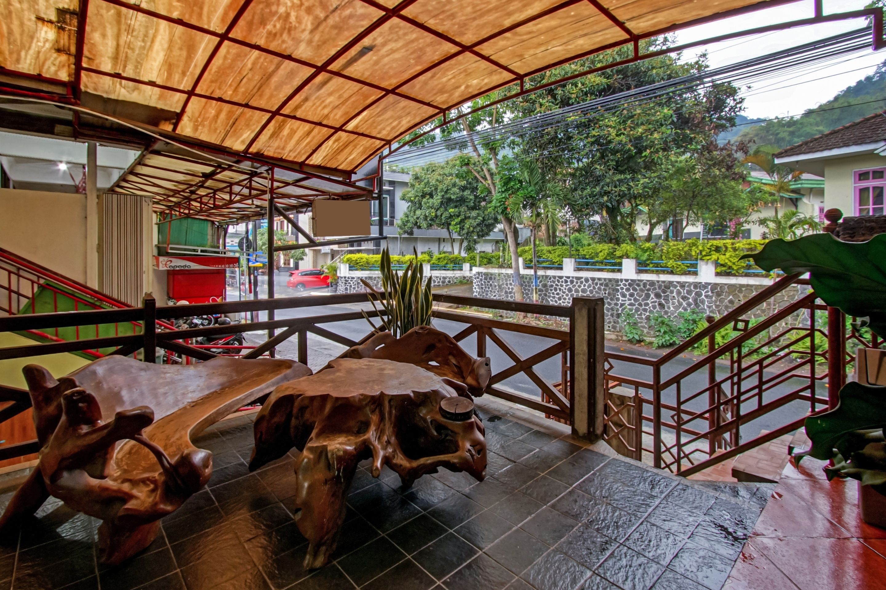 A covered outdoor area with a wooden bench and a staircase.