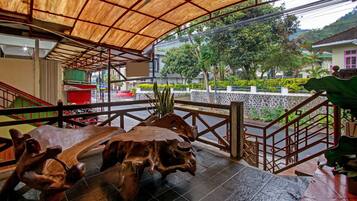 A covered outdoor area with a wooden bench and a staircase.