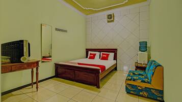 A bedroom with a bed, a sofa, a desk, and a mirror.