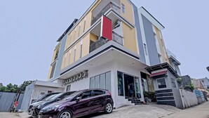 Un edifici residencial modern, de diversos pisos, amb un balcó, un garatge i una entrada ben visible.