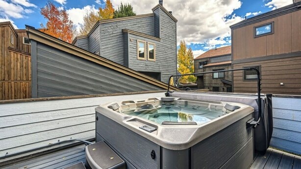 A hot tub on a wooden deck with a view of a house and trees. - Creekside Home | 3 BR/3BA | PVT Hot Tub (Frisco)