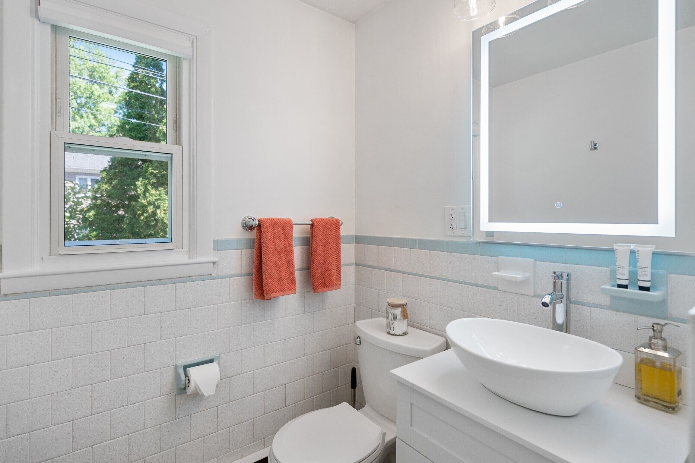Une salle de bain avec des toilettes, un lavabo et une fenêtre.