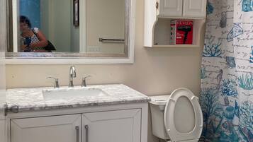 Een bad/douchecombinatie, een haardroger, een bidet, handdoeken