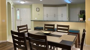 Un comedor con una mesa, sillas y una lámpara decorativa en el techo.