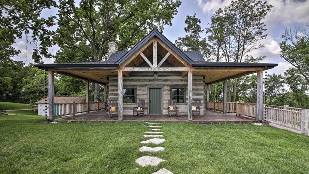 A log cabin with a covered porch, stone steps leading to the entrance, and a fenced deck area. - ‘Bross Brother's Cabin’ w/ Wraparound Porch! (Cottleville)