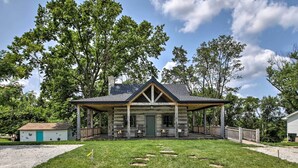 A rustic log cabin with a porch, a small shed, and a well-maintained lawn. - ‘Bross Brother's Cabin’ w/ Wraparound Porch! (Cottleville)