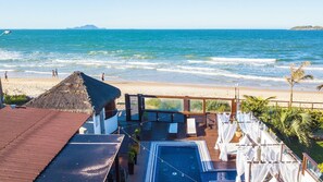 A beachside resort with a pool, a thatched-roof structure, and a view of the ocean. - Thaiji Pousada e Parador (Florianópolis)