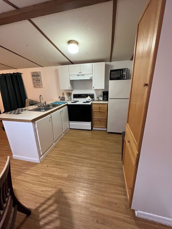 Enjoy cooking in this well-equipped kitchen with a central island, sink, microwave, and refrigerator.