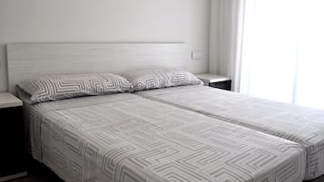 1 dormitorio y tabla de planchar con plancha