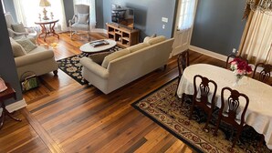 A living room with a sofa, armchairs, a coffee table, and a dining table set for four. - The Jackson House of Gamaliel (Gamaliel)
