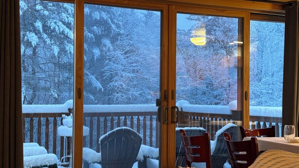 A room with a sliding glass door leading to a balcony with a wooden railing. There are two chairs and a table on the balcony. - Private quiet home close to Sunday River, Bethel village, and summer recreation  (Bethel)