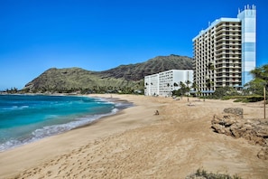 A beach with a hotel in the background. - Beachfront Condo w/ Amazing Views in Makaha Beach (Waianae)