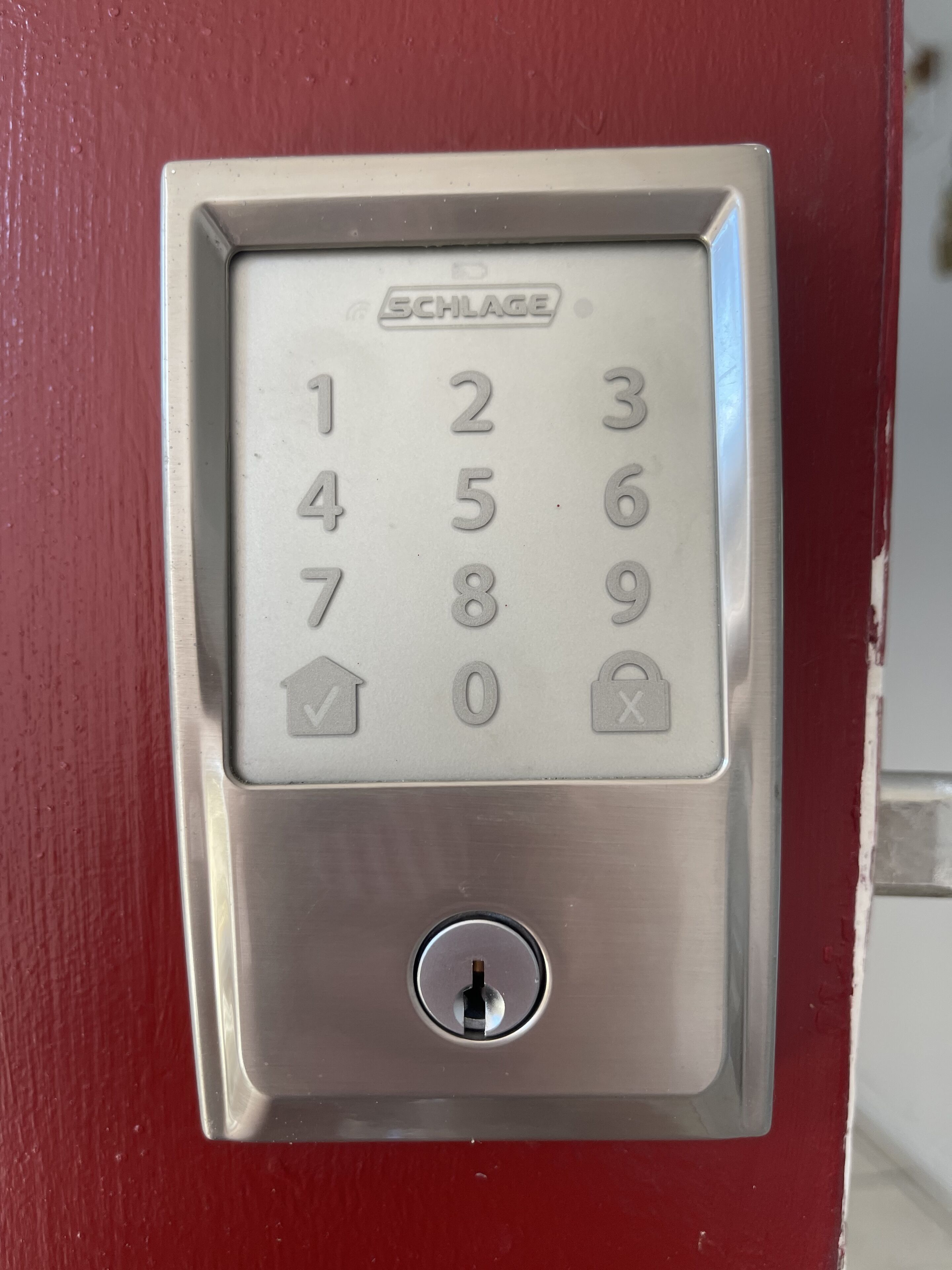 A SCHLAGE door lock with a numeric keypad and a keyhole.