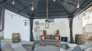 Eine Terrassengaststätte mit Korbmöbeln, einem Glastisch und Lichterketten.