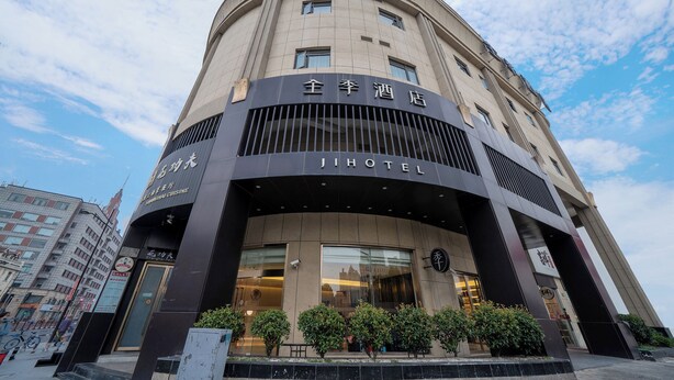 Un hotel con fachada curva, grandes ventanales y un cartel que indica que es un Jihotel.