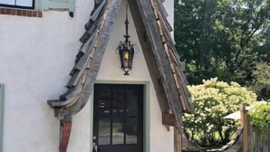 A house with a unique triangular roof structure, a black front door, and a decorative lantern above it. - The Carriage House "The Entire Place (Abingdon)