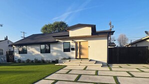 A modern two-story house with a well-maintained lawn and a driveway leading to the front door. - Sherman Oaks Cozy Guest House  (Sherman Oaks)
