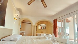 A hotel room with a large bed, a bathroom with a mirror, and a view of the outdoors. - Villa Sun Carlos by Solidays - Benissa, Costa Blanca (Benissa)