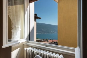 Una ventana con vistas a una montaña y un cuerpo de agua.