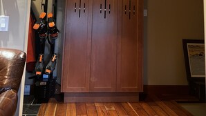 A room with a wooden wardrobe, a coat rack with shoes, and a framed picture on the wall. - Ski In Whistler Village Townhome in Best Location Telemark (Whistler)