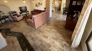 A living room with a sofa, TV, and a staircase leading to another room. - Villa Domínguez - Typical Andalusian farmhouse (Wi-Fi,BBQ, swimmingpool,relax) (lucena)