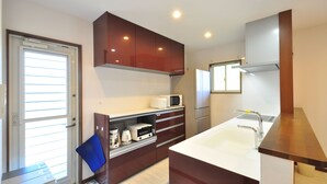 A modern kitchen with a built-in microwave, coffee maker, and a sink. - Sun Akaishibeach no Yado (Ishigaki)