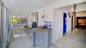 A hallway with a desk, a clock, and a blue door.