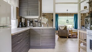 A modern kitchen with dark wood cabinets, a central island, and a dining area with a view.