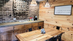 A cozy dining area with a wooden table and chairs, a brick wall, and a whiteboard with a motivational quote. - Farmhouse by the Lake with FAST Fiber Internet + Washer/Dryer! (Campton)