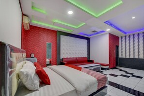 A modern hotel room with a bed, bedside table, and a red sofa. - OYO 4010 Zaara Guest House Syariah (Padang)