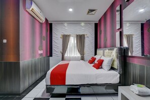 A modern hotel room with a large bed, a bathroom, and a mirror. - OYO 4010 Zaara Guest House Syariah (Padang)