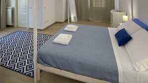 A bedroom with a four-poster bed, a patterned rug, and a wooden ceiling. - Relais Gregorio - Villa with private pool and garden in Irpinia (Paternopoli)