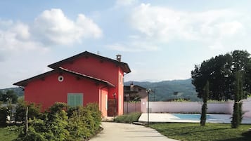 Stunning villa with a traditional Mediterranean design, surrounded by lush greenery and a pool.