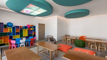 A classroom with colorful storage units, wooden tables, and chairs.