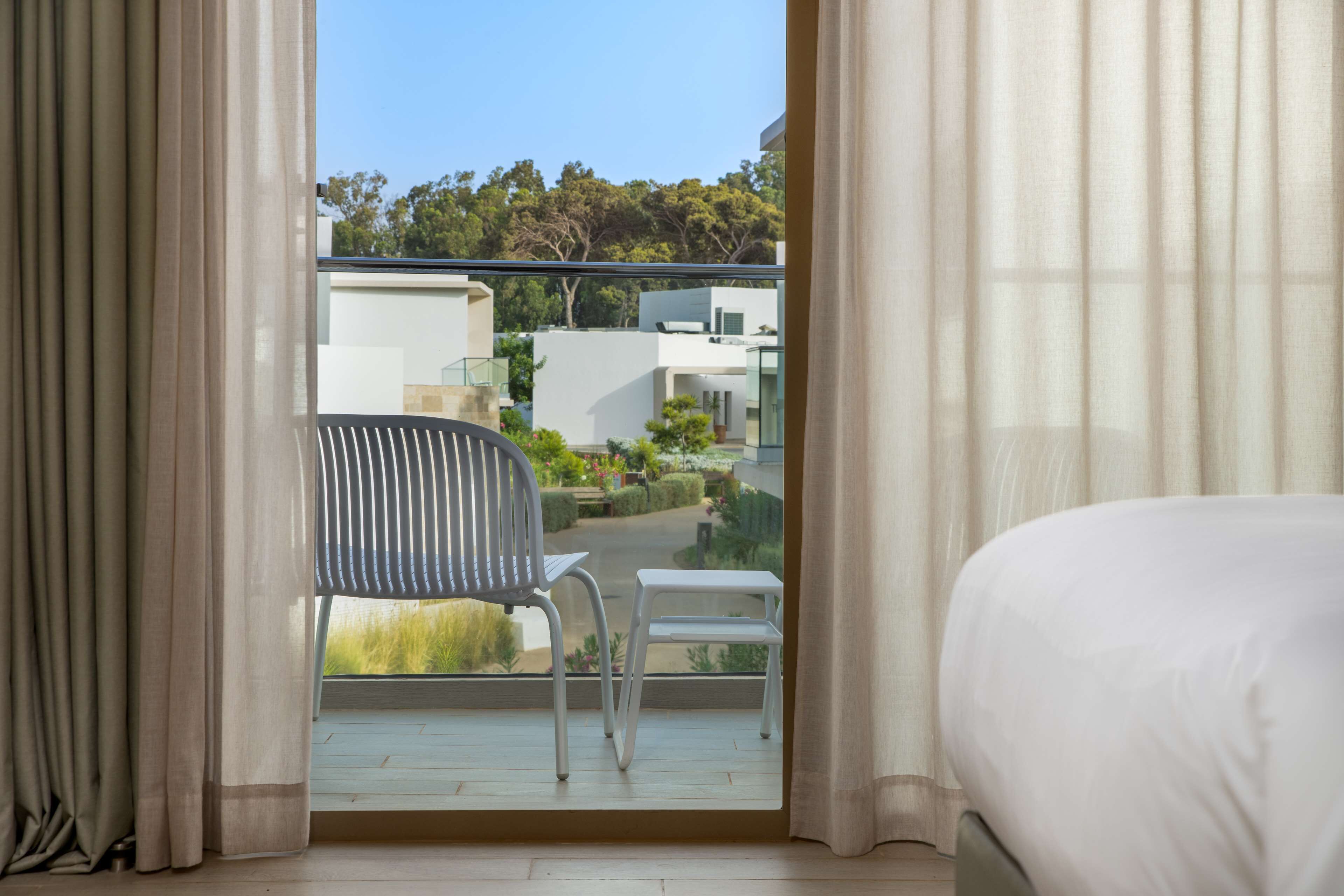 A balcony with a view of a modern building and greenery.
