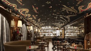 Eine Bar mit Klavier, Holzhöhlen und einer Decke mit Sternenmustern.