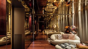 Un intérieur moderne avec un espace salon central, une cloison en verre et un plancher en bois.