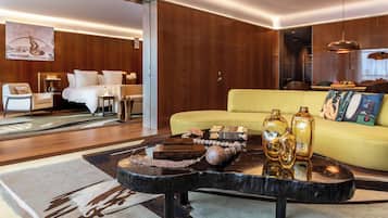 A modern living room with a yellow sofa, a black coffee table with decorative items, and a wooden floor.