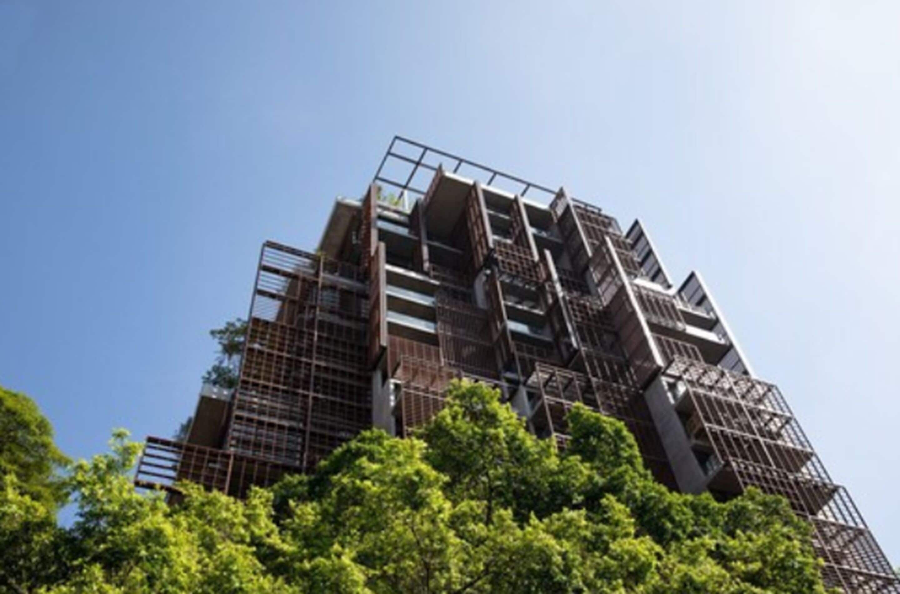 A multi-story building with a modern architectural design, featuring a series of balconies and a complex facade structure.