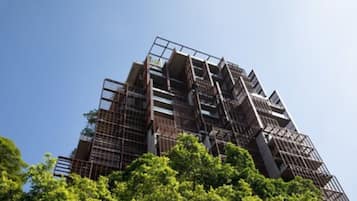 A multi-story building with a modern architectural design, featuring a series of balconies and a complex facade structure.
