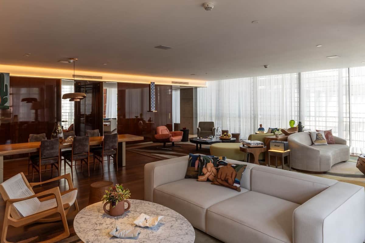 Ein geräumiger Wohnbereich mit Sofa, Sesseln, einem Esstisch und einem Couchtisch.