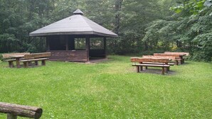 A gazebo with benches in a grassy park area.