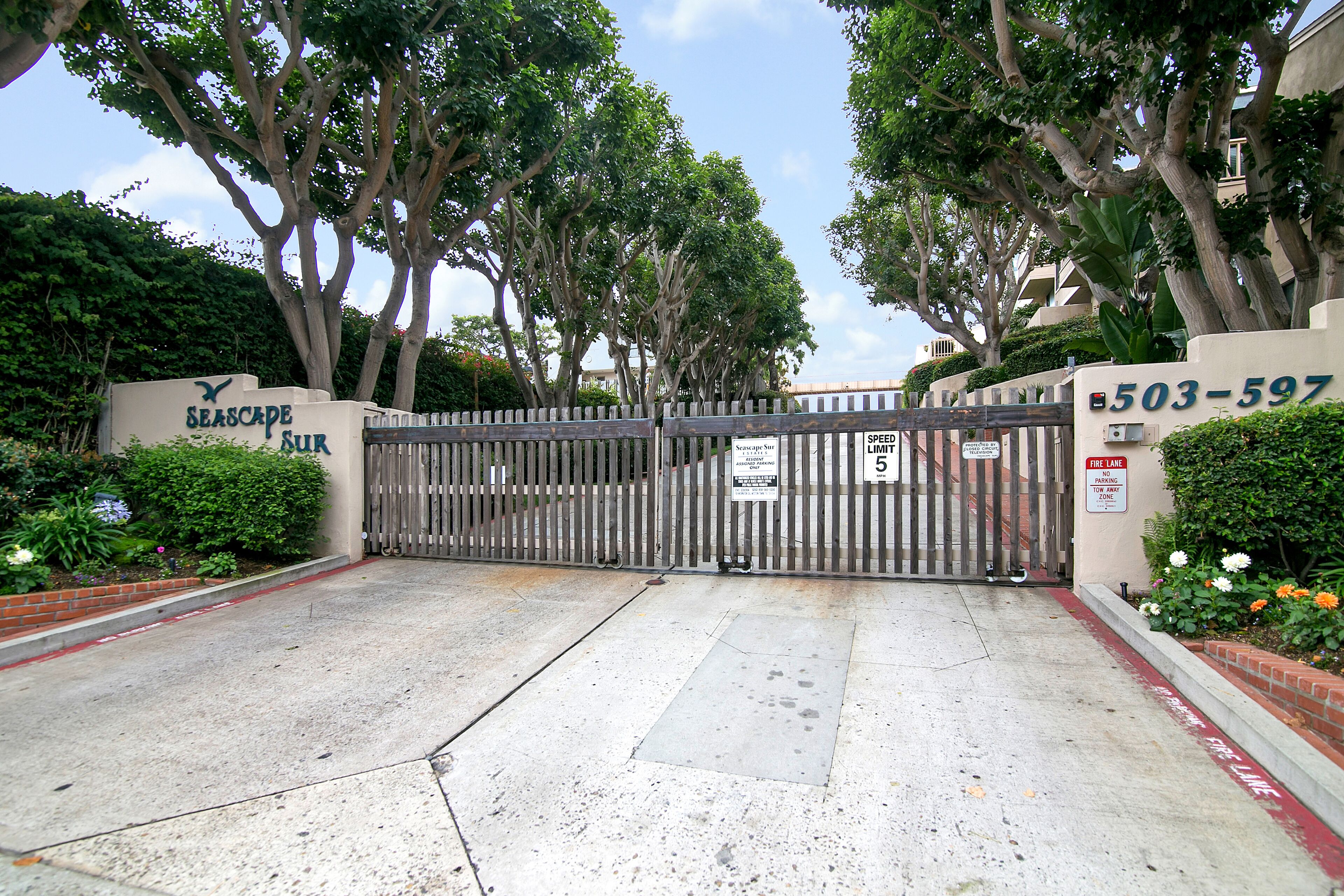 A gated entrance with a sign reading "Seascape Sub" and a phone number "503-597".