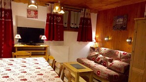 Une pièce confortable avec un lit, un canapé, une table et un téléviseur.