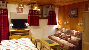 Une pièce confortable avec un lit, un bureau avec une télévision, un canapé et une table.