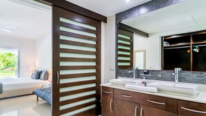 Une salle de bain moderne avec un grand miroir, deux vasques et des meubles en bois.