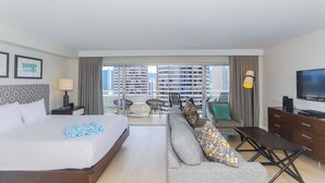 A hotel room with a large bed, a sofa, a TV, and a balcony with a view of high-rise buildings. - Ilikai Hotel, Breezy City Views! Great for your Hawaiian Getaway! (Honolulu)