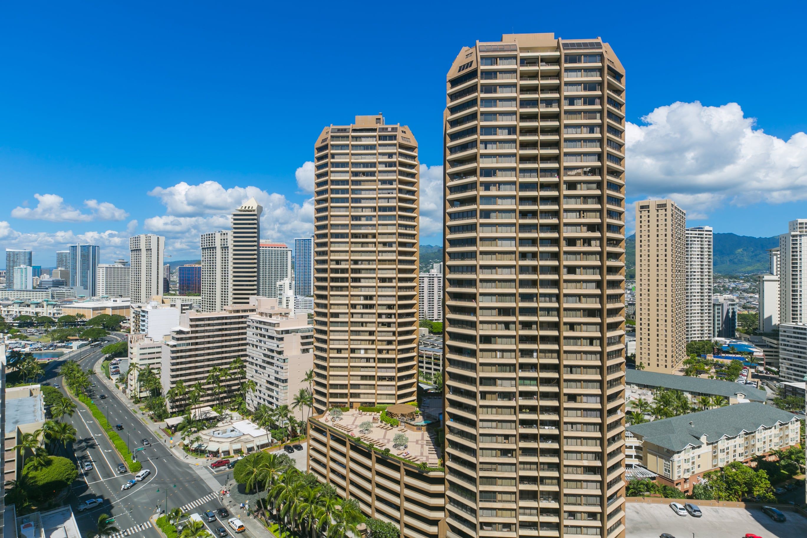 A high-rise building with a modern architectural design, featuring multiple balconies and a prominent entrance.