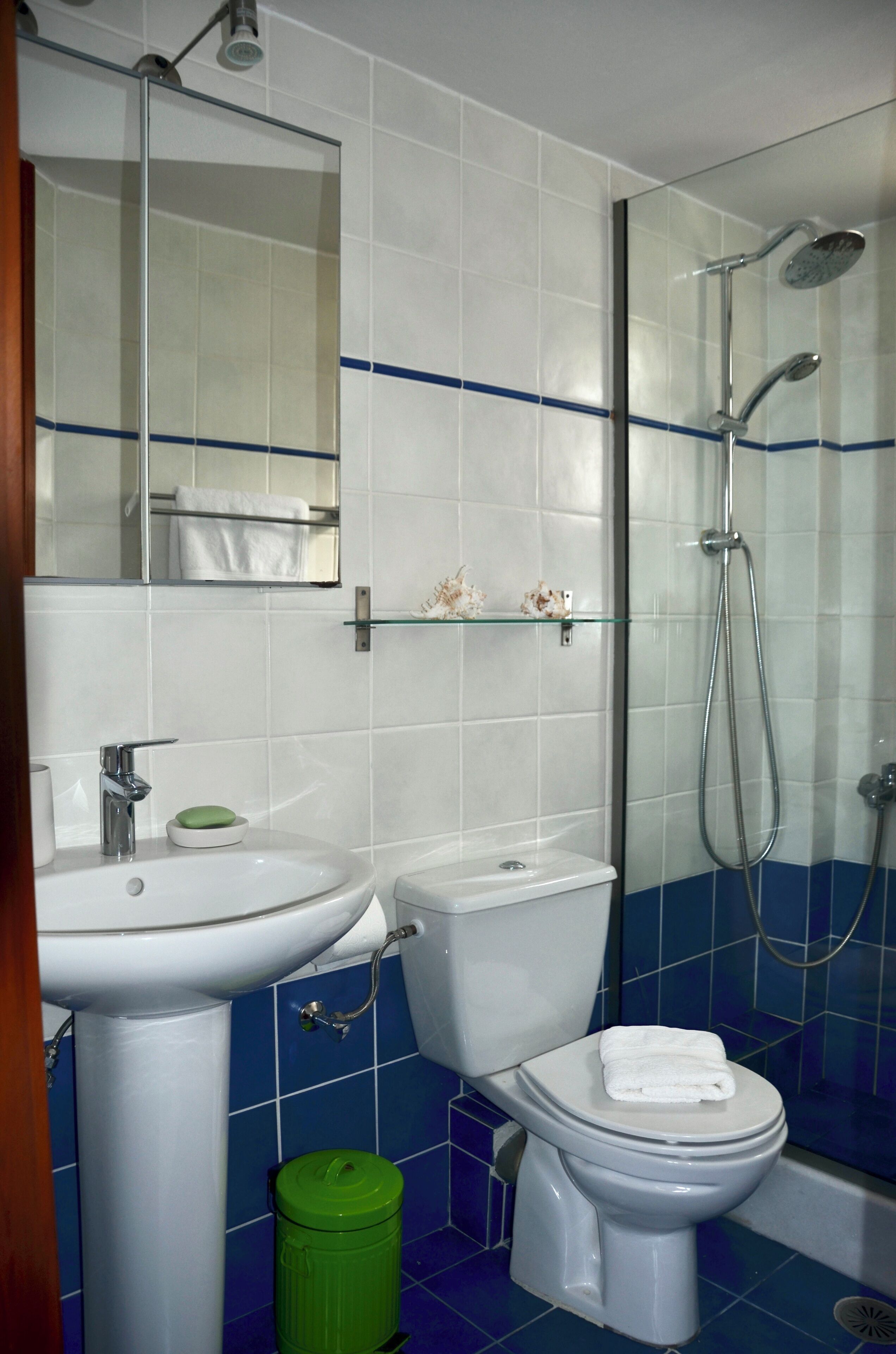 A bathroom with a sink, toilet, and shower.